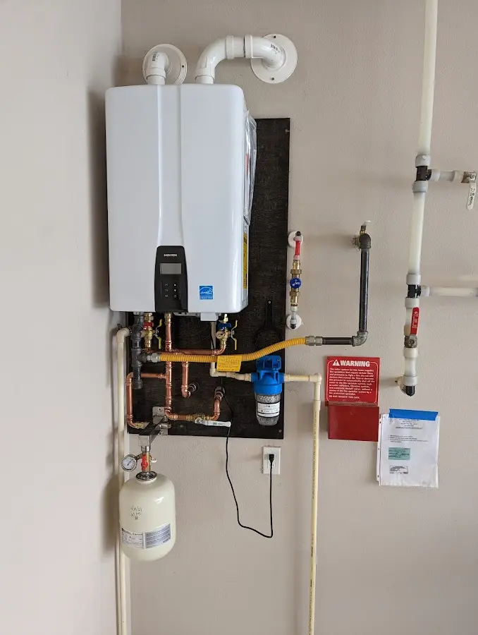 Professional plumber installing copper piping in a Grinnell home